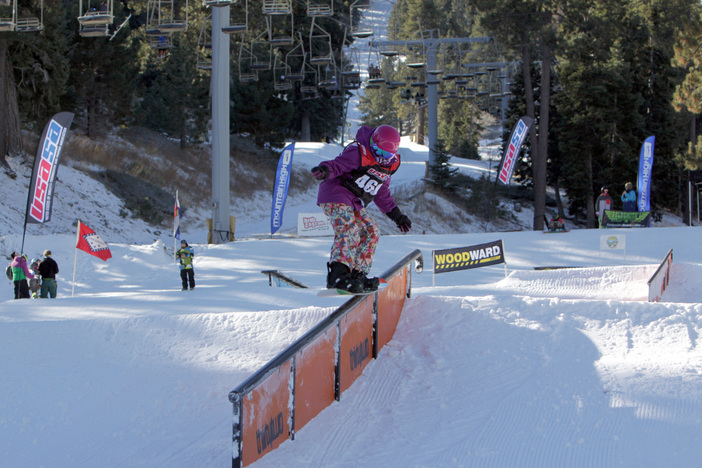 Young, female shredder getting a Tail Press during the USASA Rail Jam.